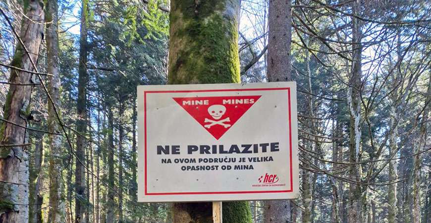 A sign posted on a tree in Eastern Europe warns of active land mines.